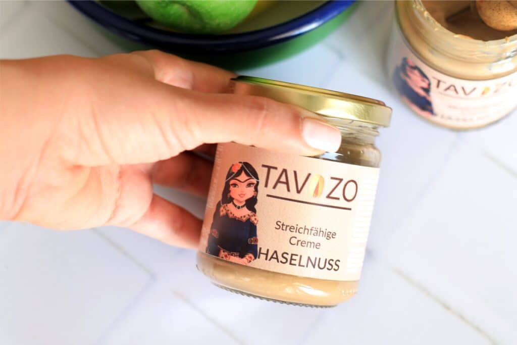 Hazelnut butter in a jar labeled 'tav zo', showcasing a creamy texture and rich brown color.