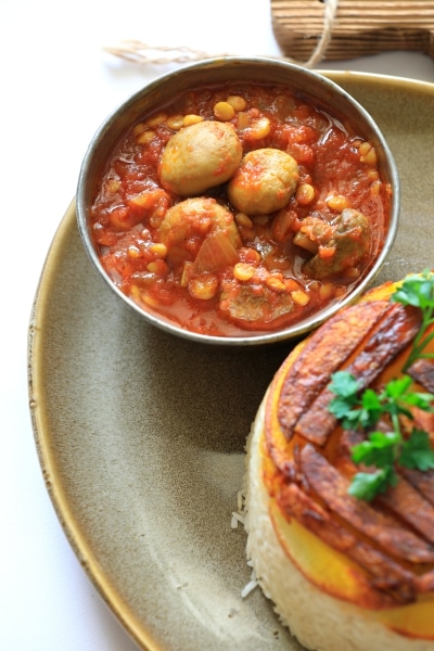 A plate featuring a bowl of food alongside a bowl of soup, arranged neatly for a meal setting.