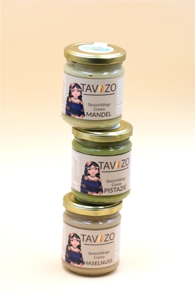 Three jars of green and yellow paste featuring a woman on the label, displayed against a neutral background.