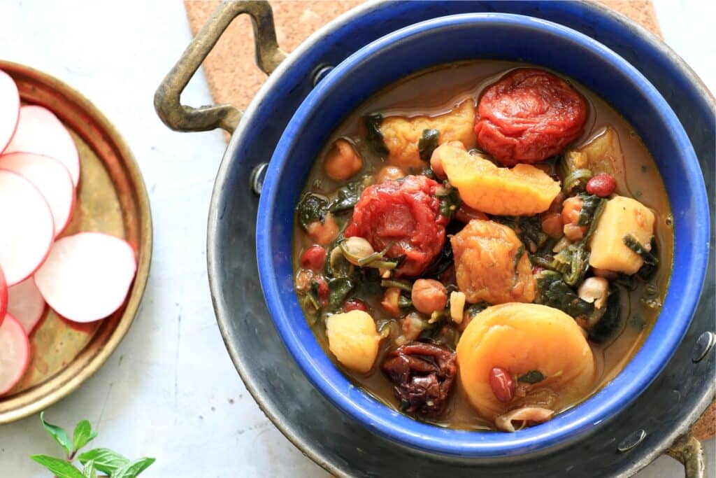 A bowl of hearty stew featuring radishes and potatoes, garnished with fresh herbs.