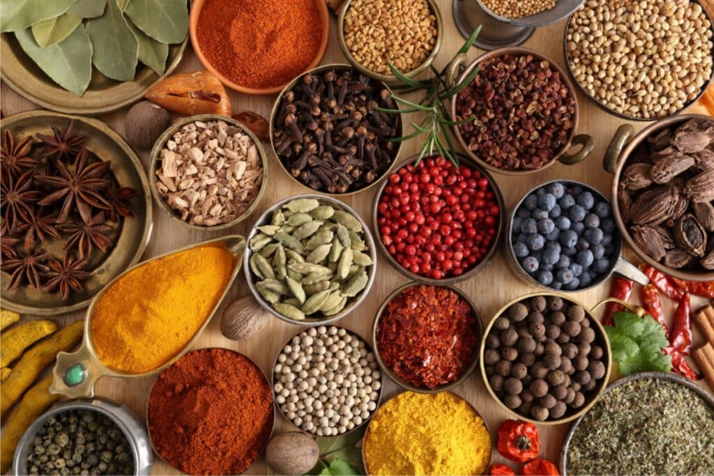 A variety of spices and herbs displayed in small bowls, showcasing vibrant colors and textures.