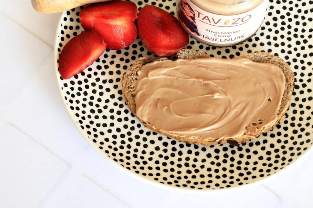 A plate featuring a generous spread of peanut butter accompanied by fresh strawberries.