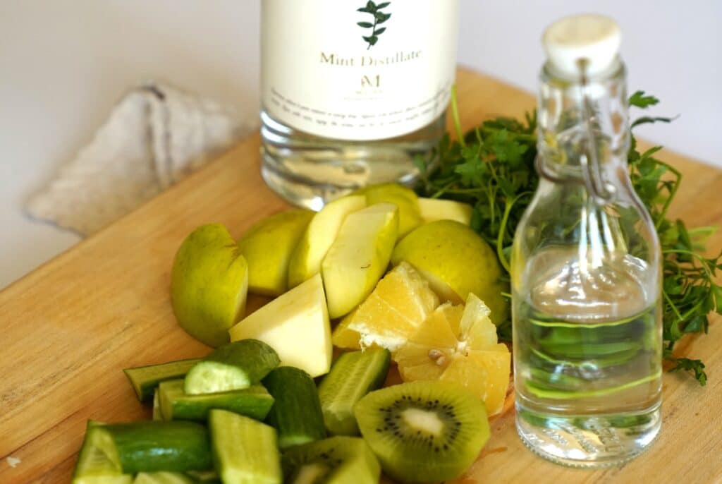 Ingredients for a vodka cocktail, including vodka, mixers, garnishes, and ice, arranged on a countertop.